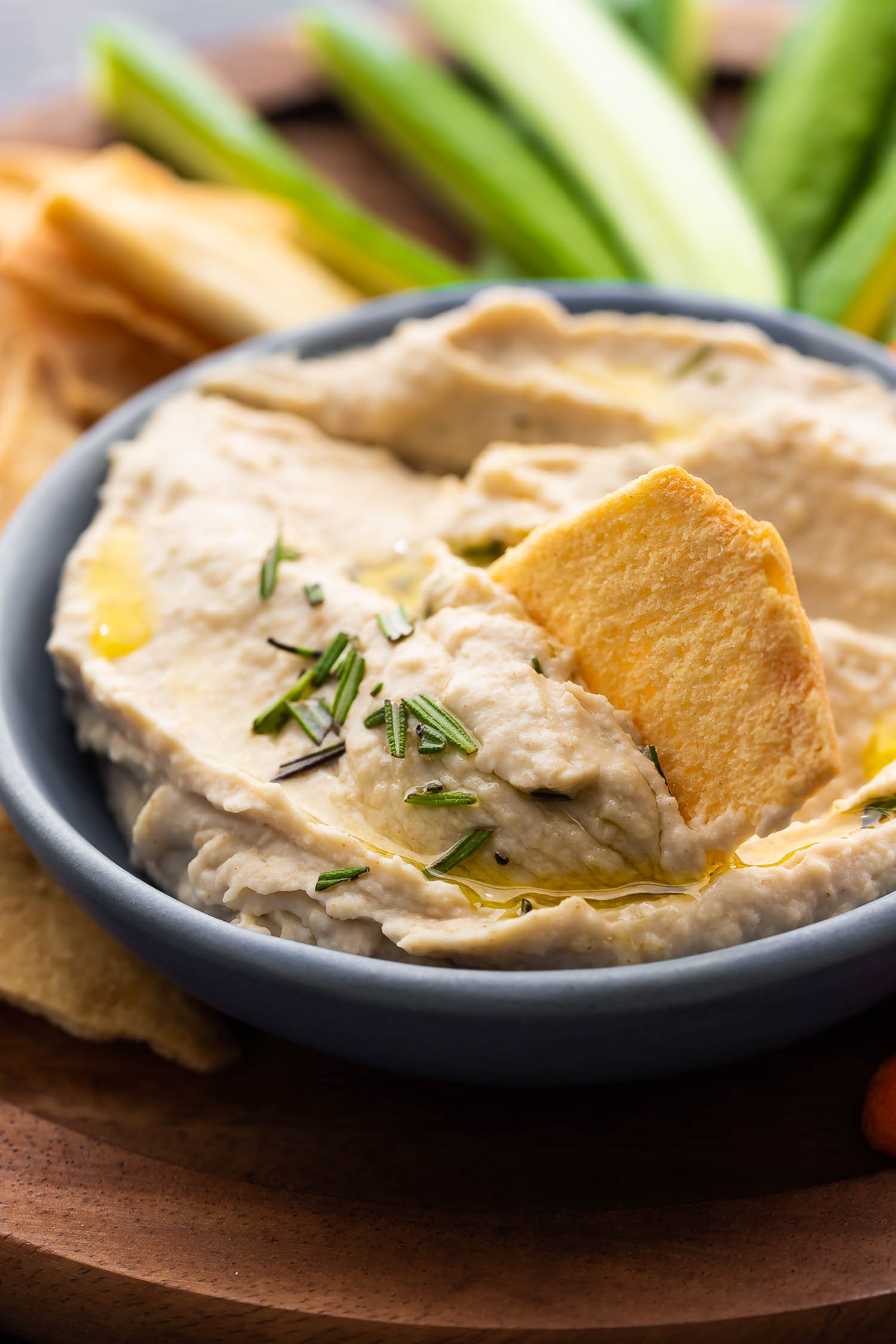 close up view of pita chip in white bean dip