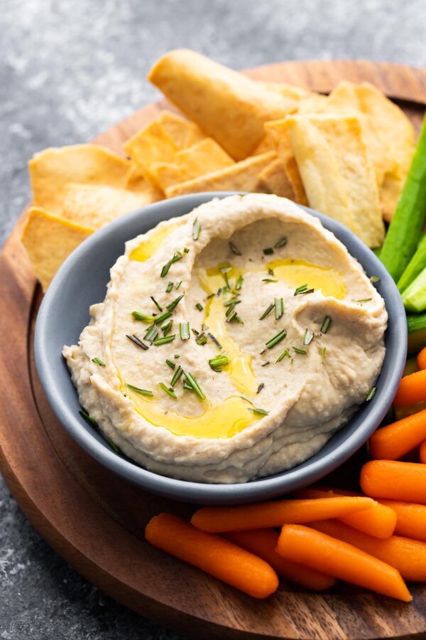 white bean dip on platter with vegetables and pita chips