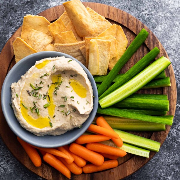 white bean dip on platter with vegetables and pita chips
