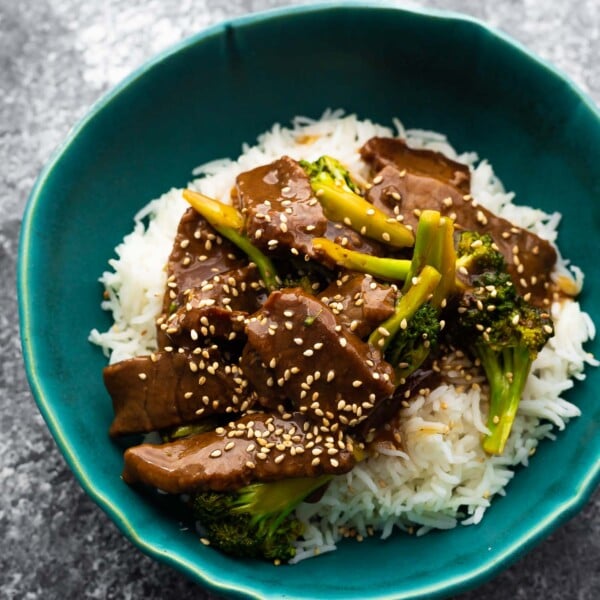 beef and broccoli served over rice in blue bowl