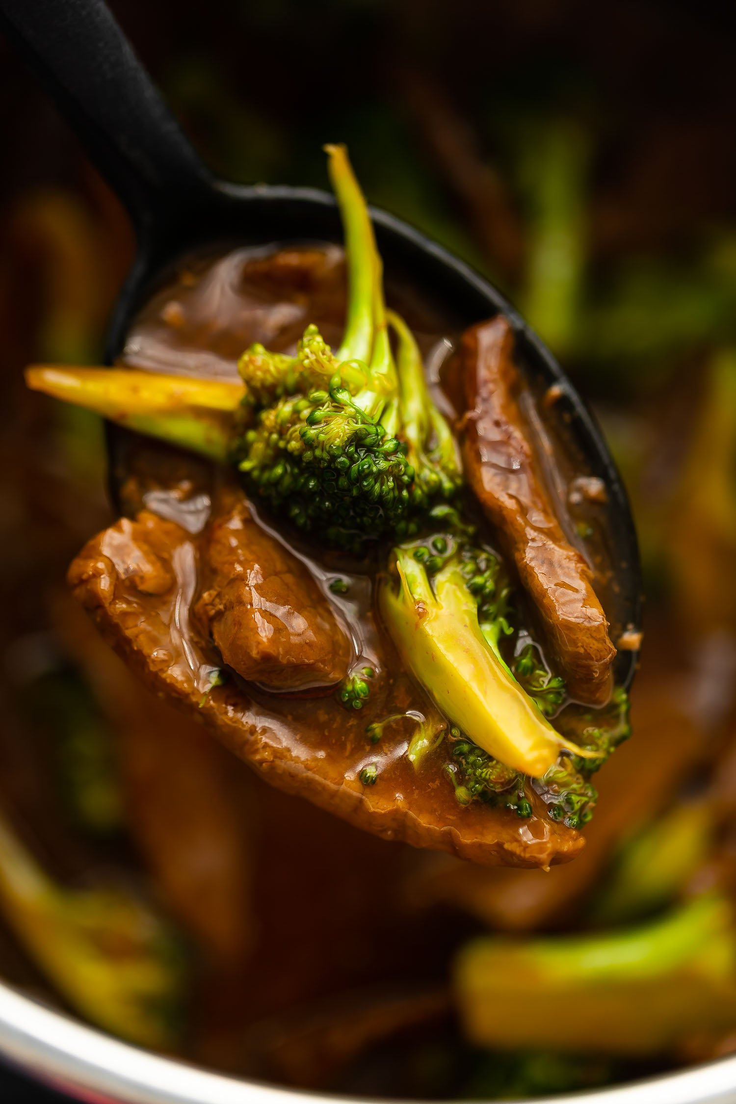 close up shot of beef and broccoli on a spoon