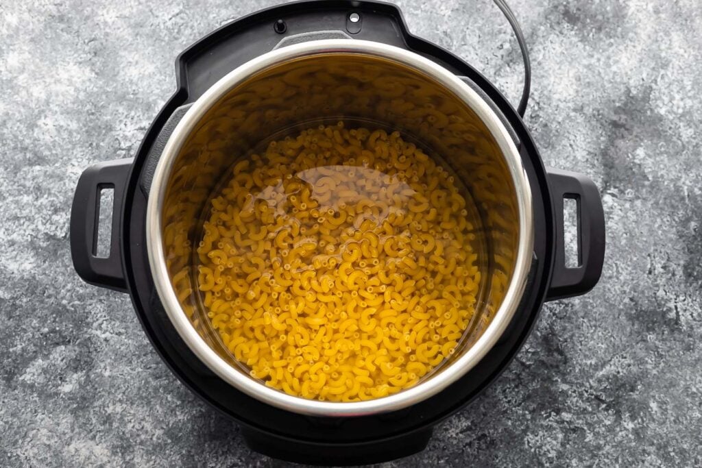 macaroni and water in the instant pot before cooking through