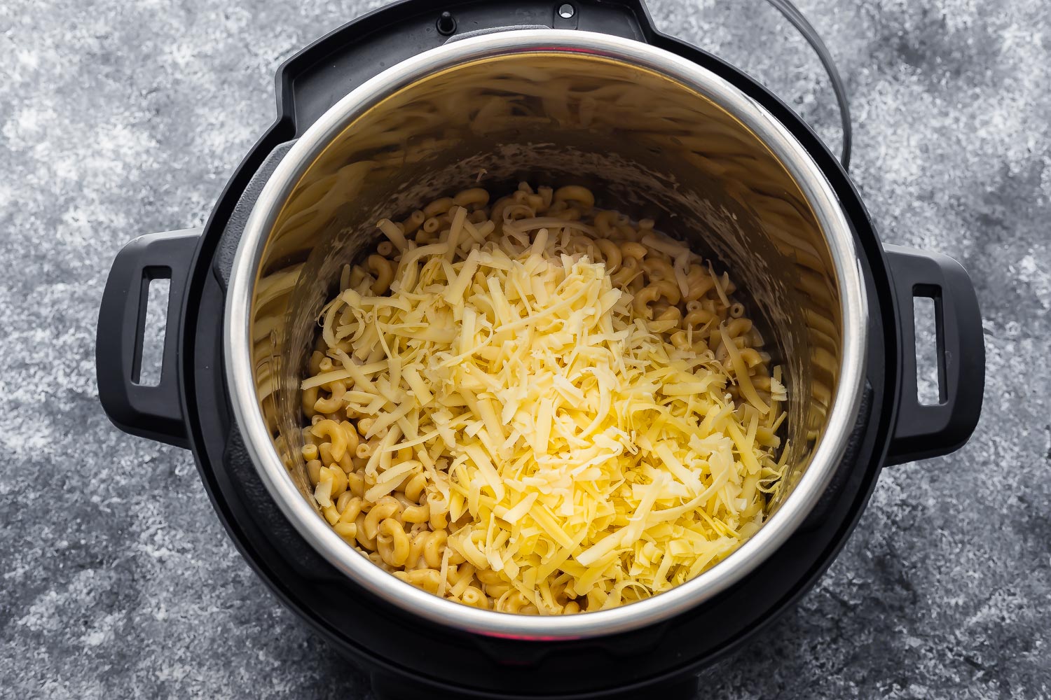 overhead view of cheese added to macaroni in the instant pot