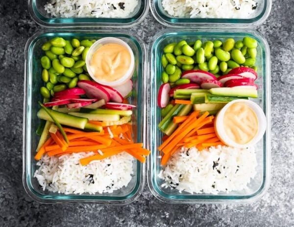 overhead shot of glass meal prep containers filled with vegan sushi bowls