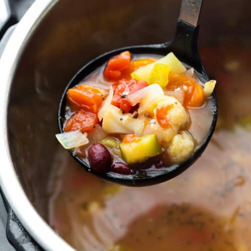 close up view of vegetable soup on ladle