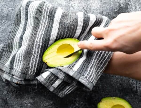 slicing into an avocado resting on a towel