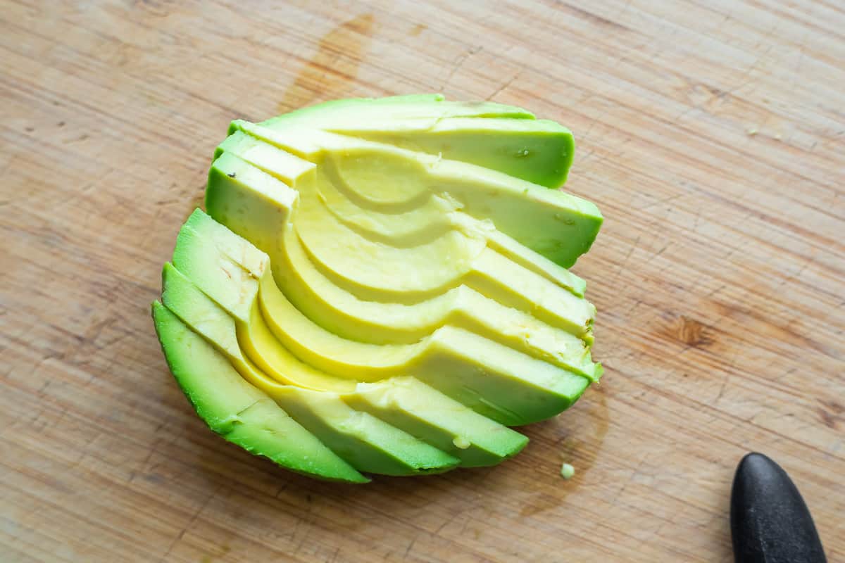 avocado sliced and fanned out on cutting board