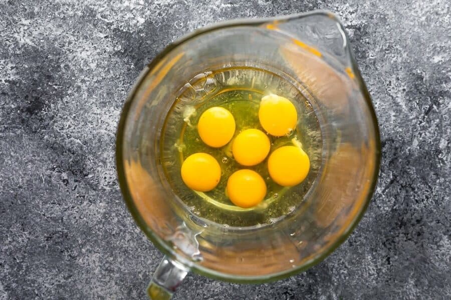6 broken eggs in large glass mixing bowl