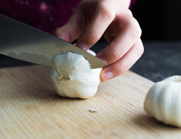 cutting the top off a head of garlic