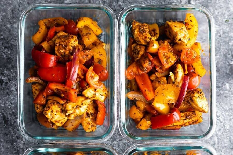 cajun chicken and veggies portioned out into glass meal prep containers, from overhead