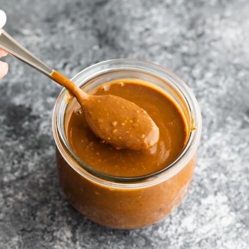 spoon showing texture of peanut sauce in jar