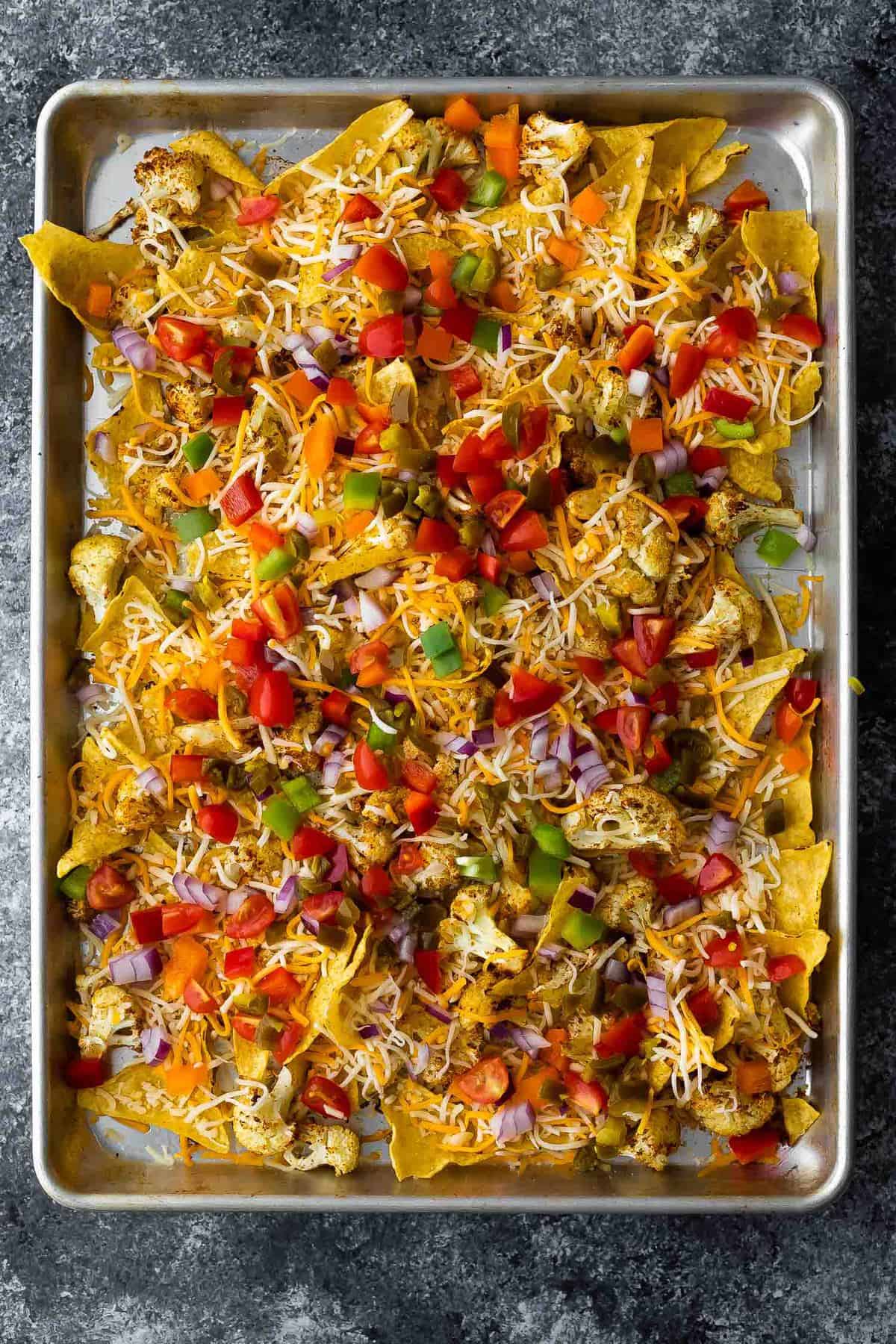 cauliflower nachos on sheet pan before melting