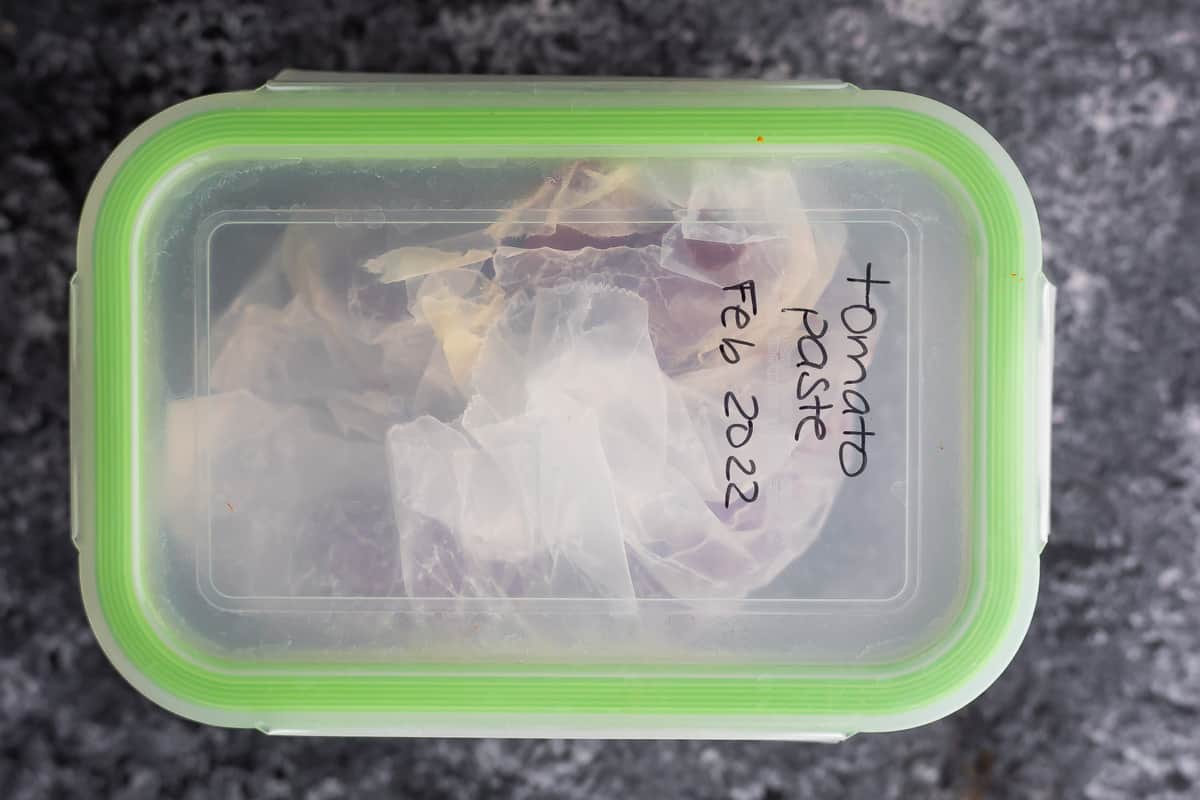 meal prep container labelled 'tomato paste feb 2022'