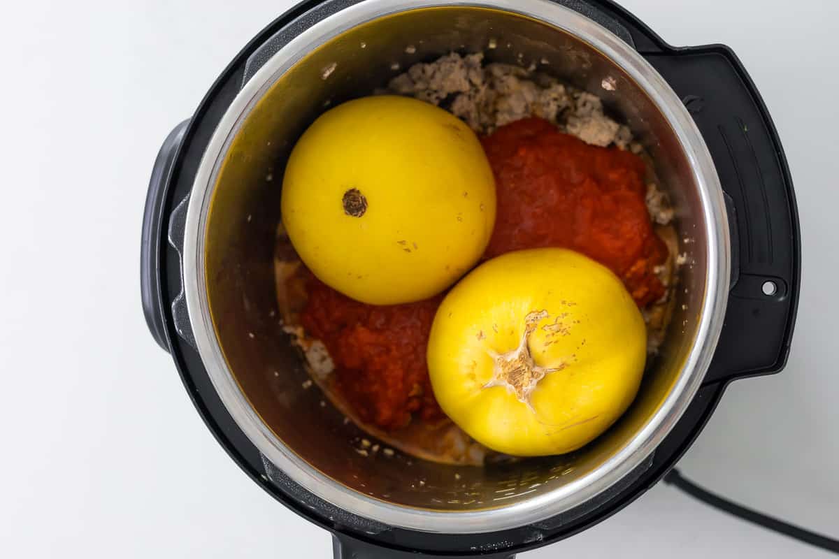 overhead view of spaghetti squash and meatsauce in instant pot before cooking
