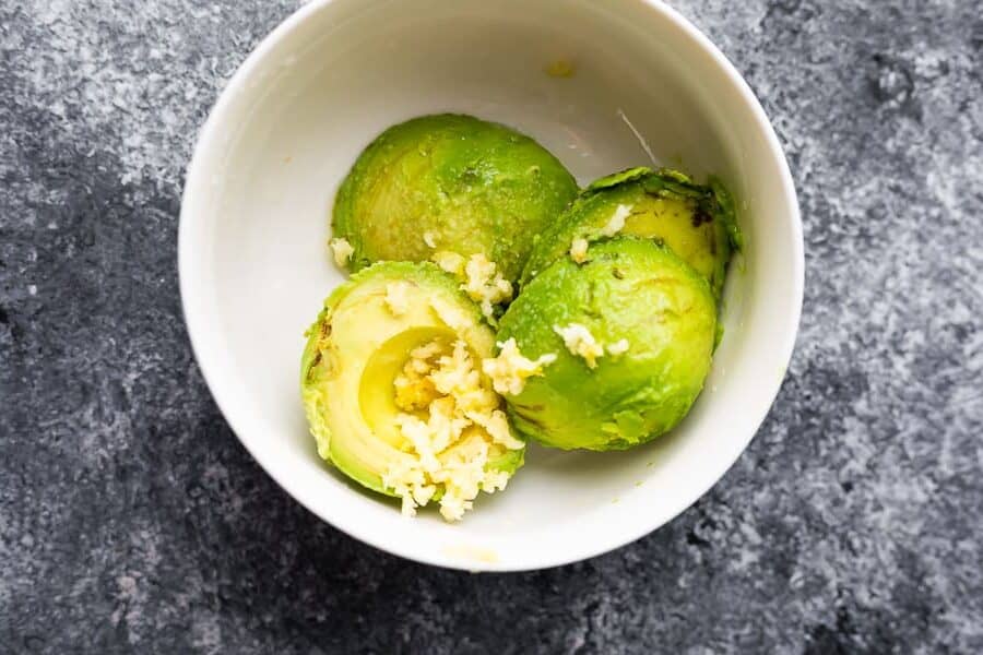 avocado and crushed garlic in bowl from overhead