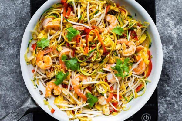 overhead shot of zucchini noodle pad thai in large white bowl