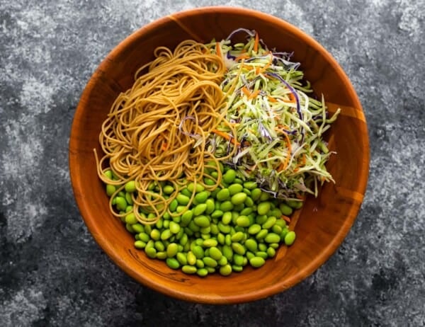 ingredients edamame sesame noodles in salad bowl before mixing up