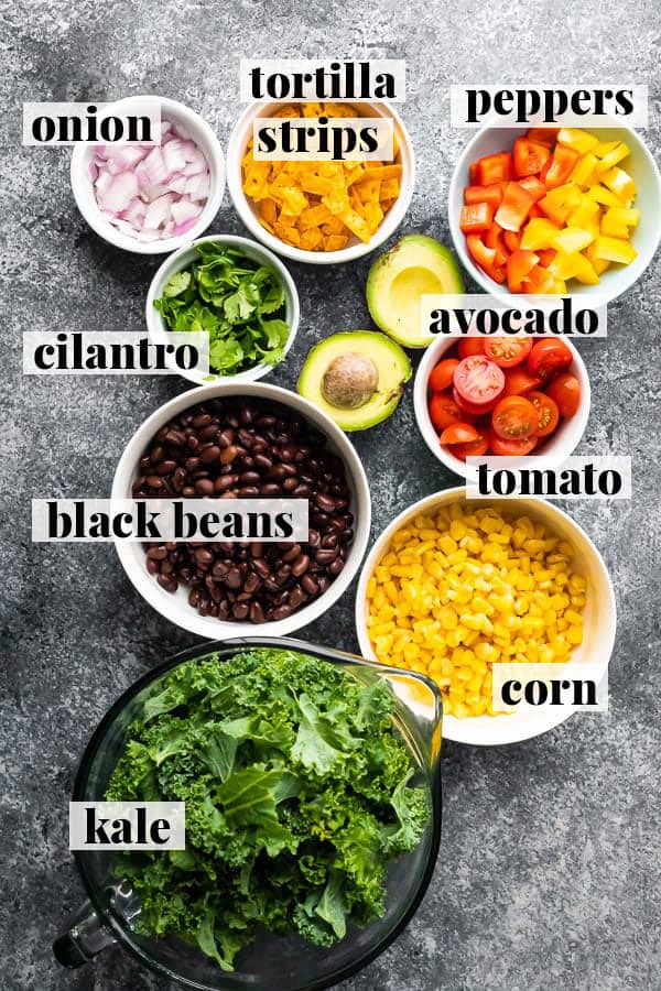overhead view of chopped kale salad ingredients in bowls