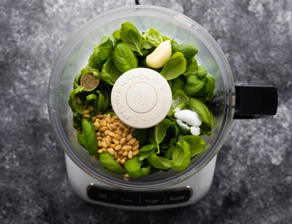 Classic Basil Pesto ingredients loaded into food processor ready to blend.