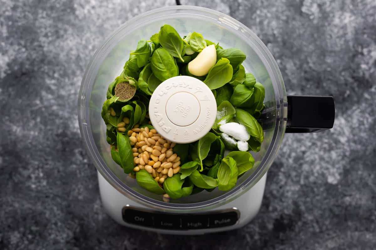 Classic Basil Pesto ingredients loaded into food processor ready to blend.