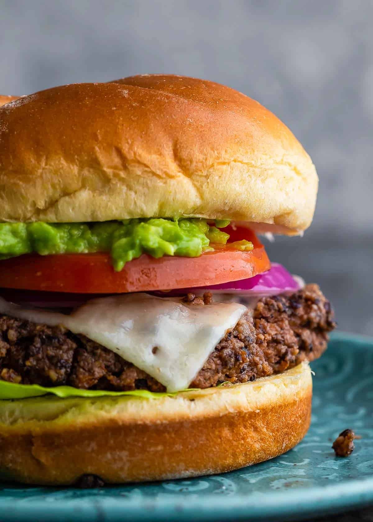 an assembled black bean burger on a blue plate