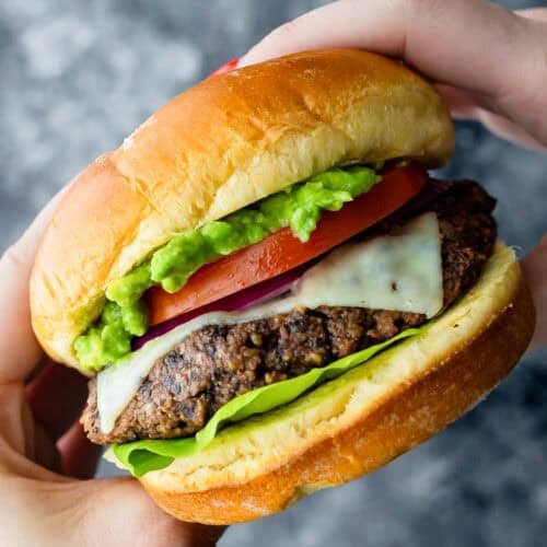 a hand holding a black bean burger