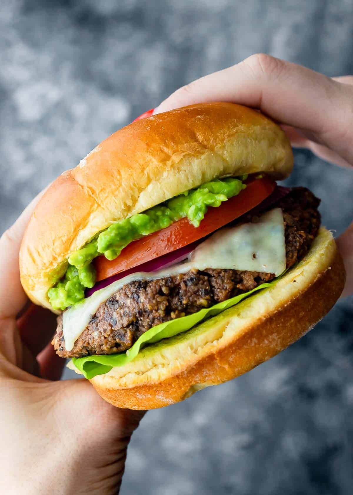 a hand holding a black bean burger