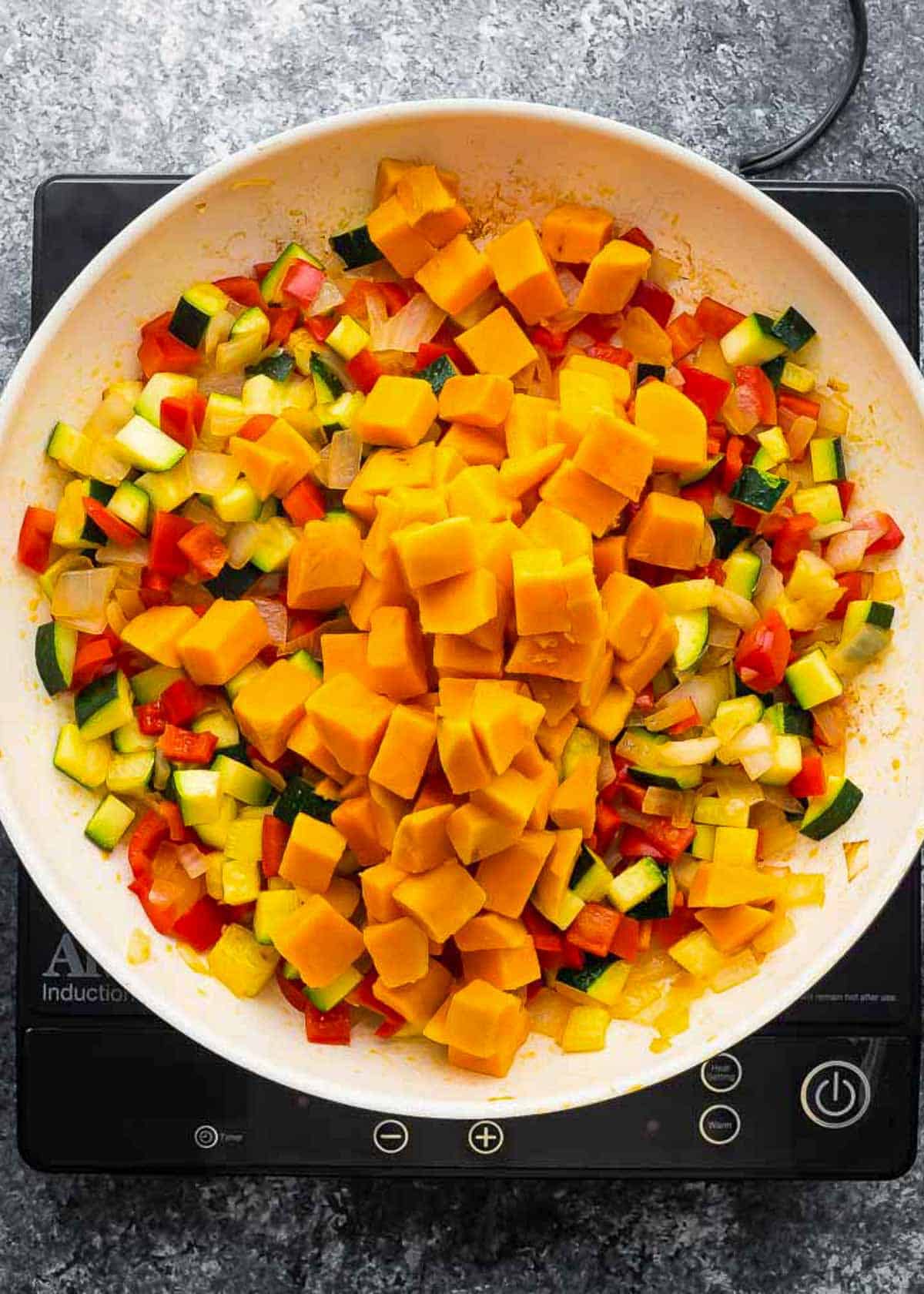 cooked vegetables and sweet potatoes in a skillet