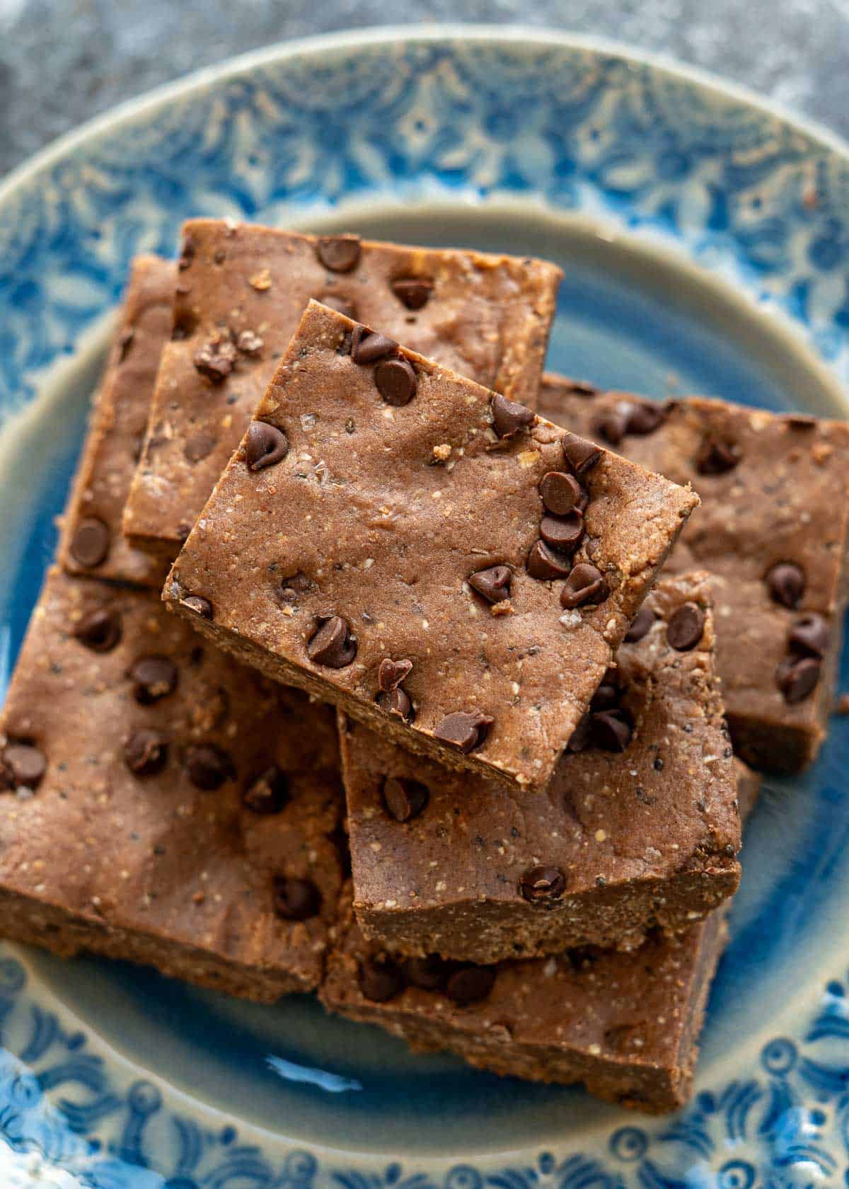 An overhead shot of homemade protein bars on a blue plate