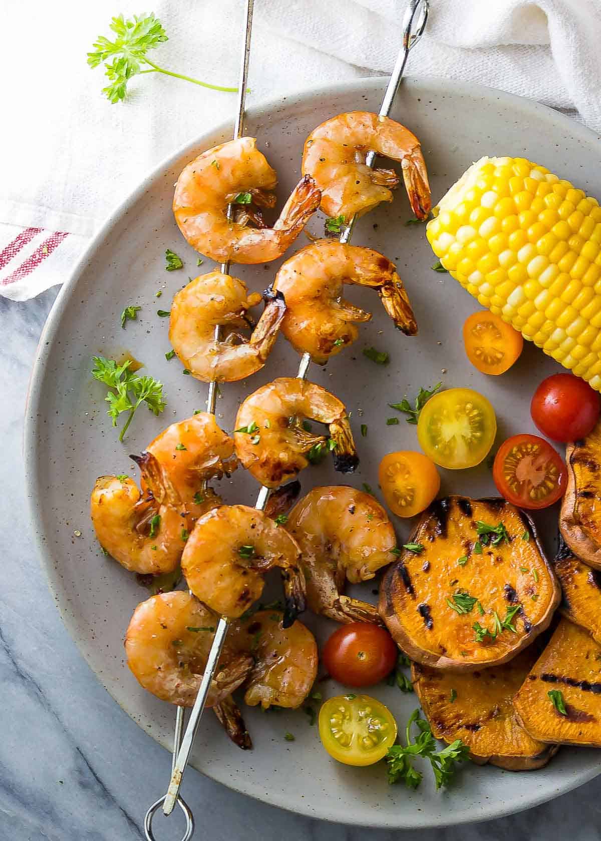 chipotle shrimp skewers on a plate with grilled vegetables