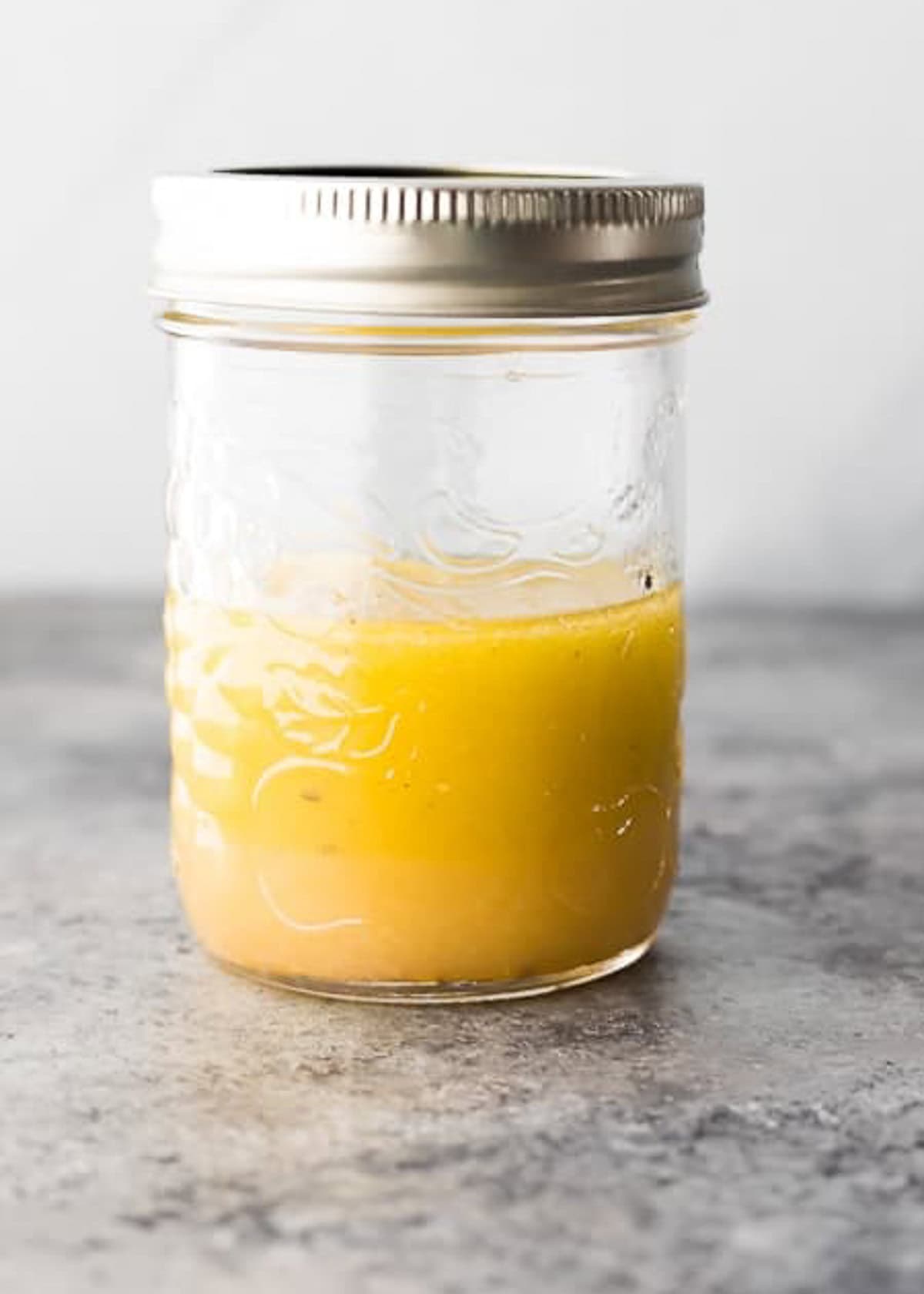 A jar of salad dressing sitting on a table.