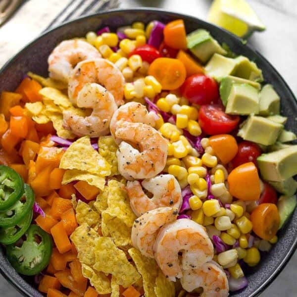 A bowl of shrimp, corn, and vegetables.