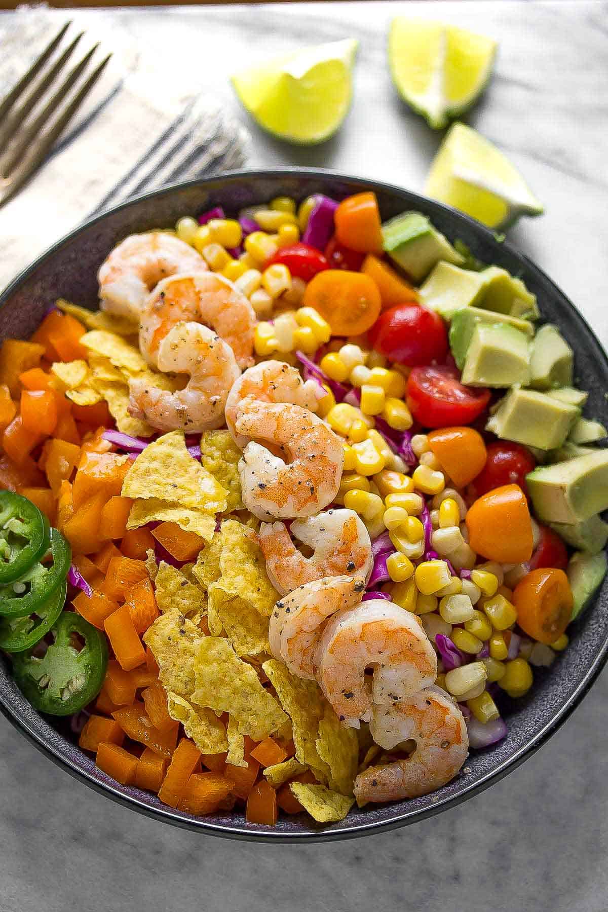 A bowl of shrimp, corn, and vegetables.