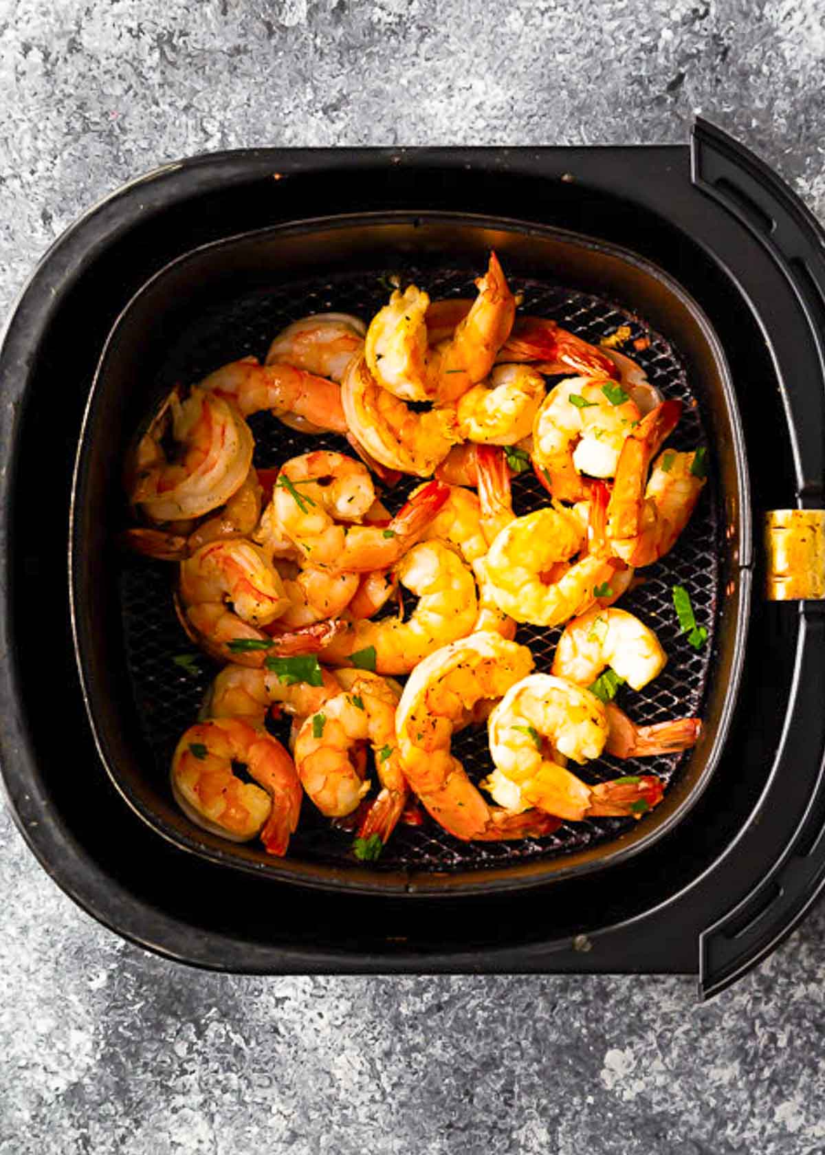 A pan filled with shrimp in an air fryer.