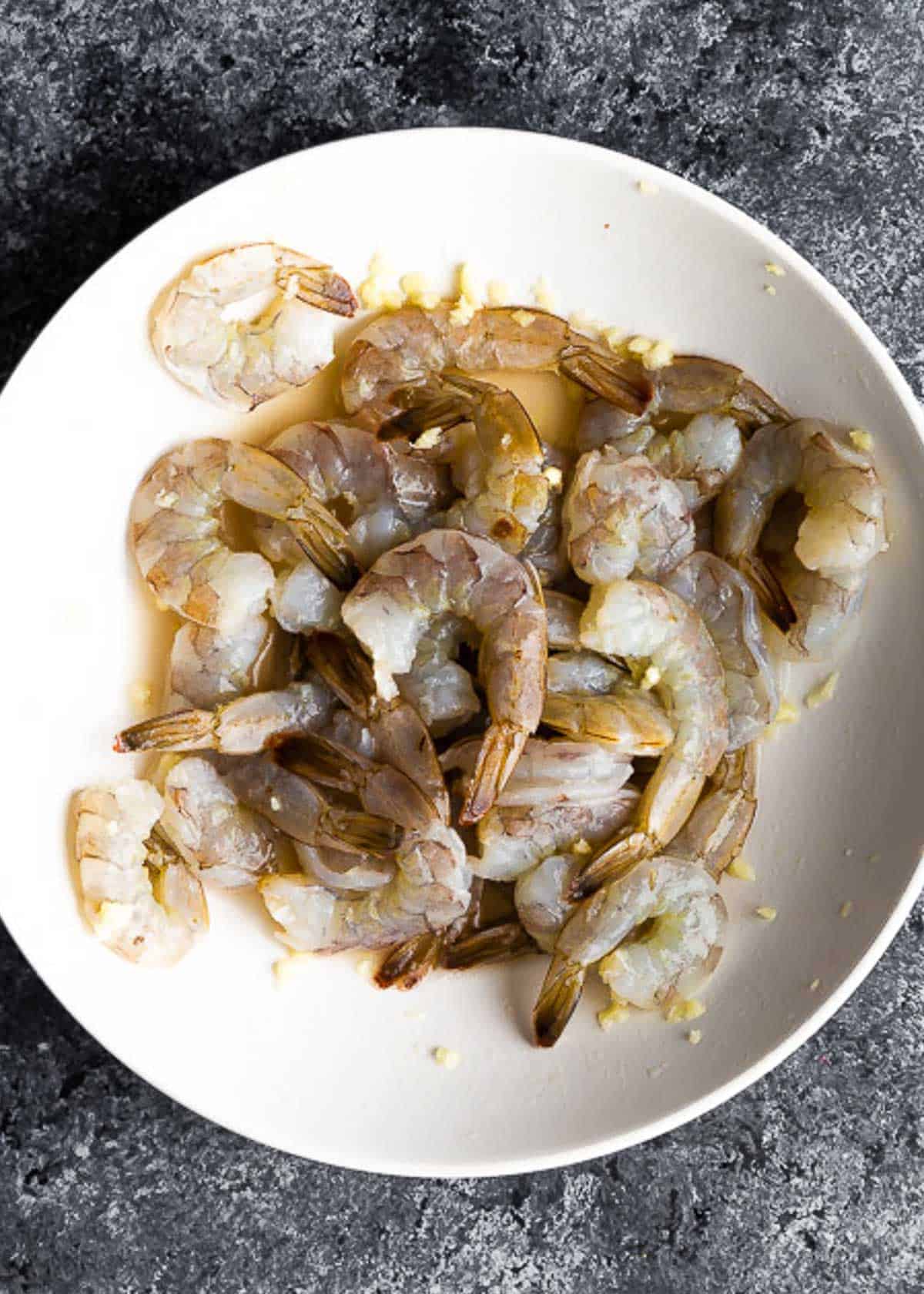 A white plate with shrimp and sauce.