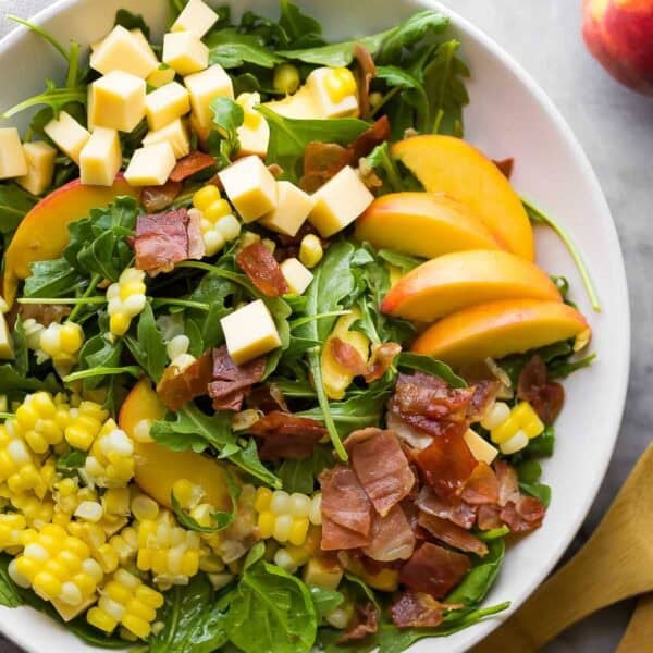 an overhead shot of an assembled summer salad with peaches and corn