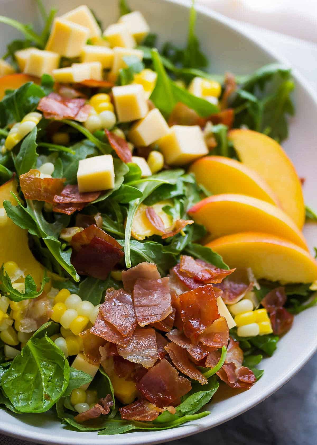 a closeup shot of summer salad in a white bowl
