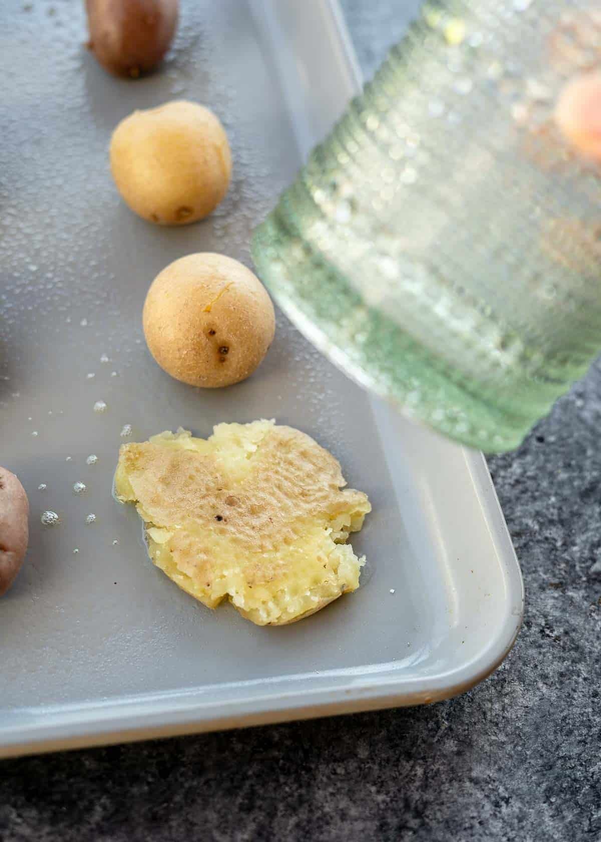 a glass being used to smashed potatoes