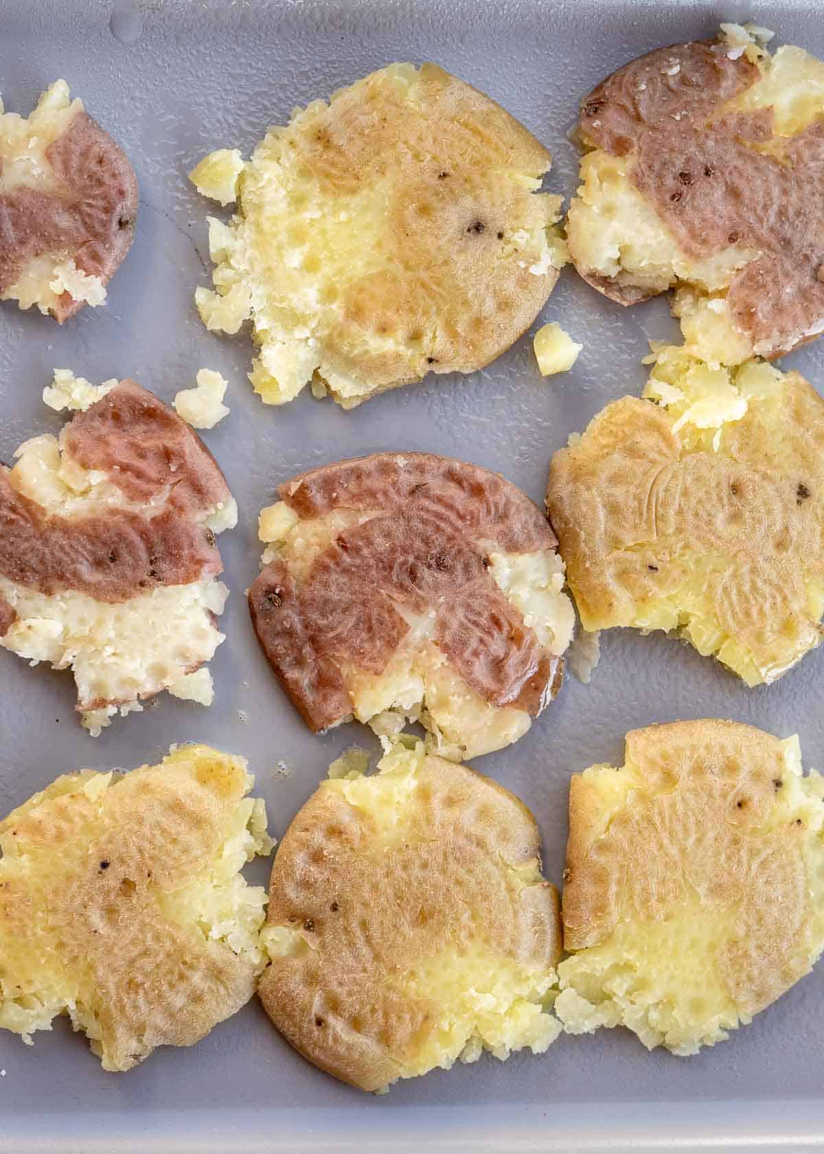 flat, smashed potatoes on a baking sheet