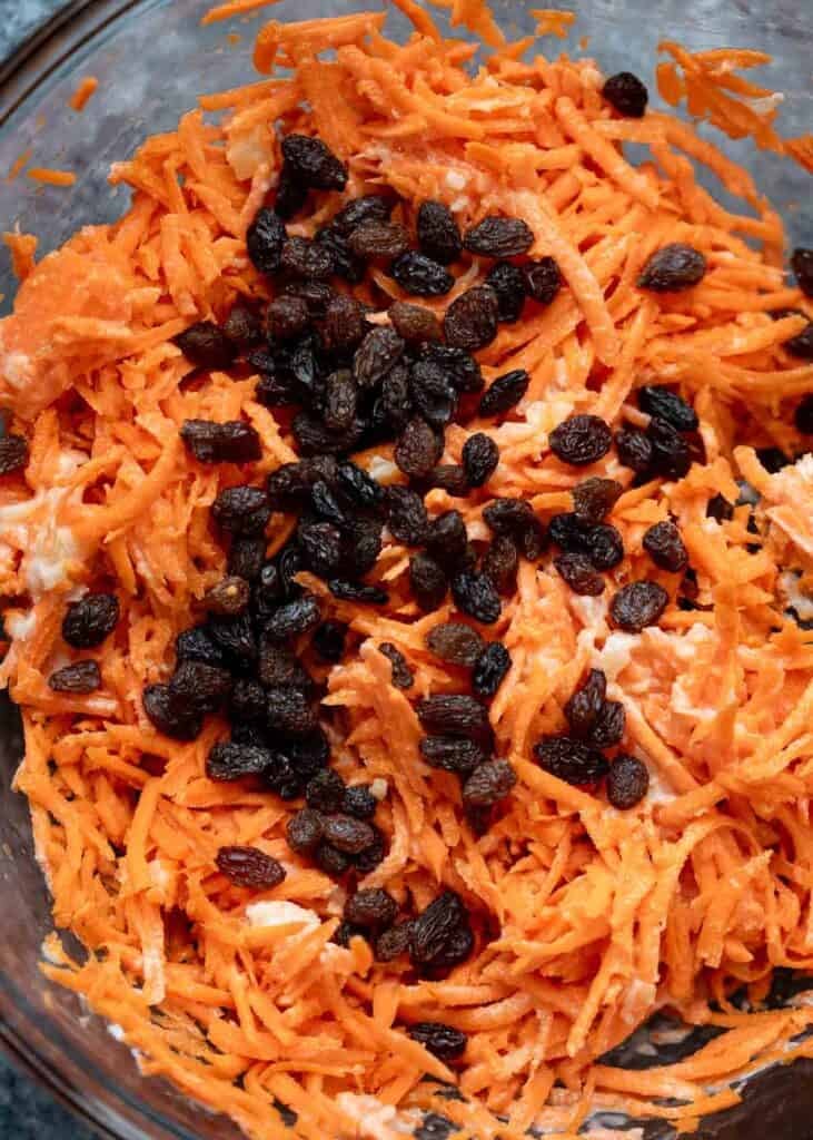 shredded carrots, crushed pineapples, and juicy raisins in a bowl