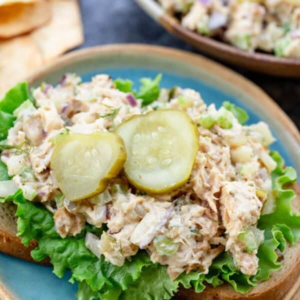 a plate with dill pickle chicken salad and lettuce on a piece of bread