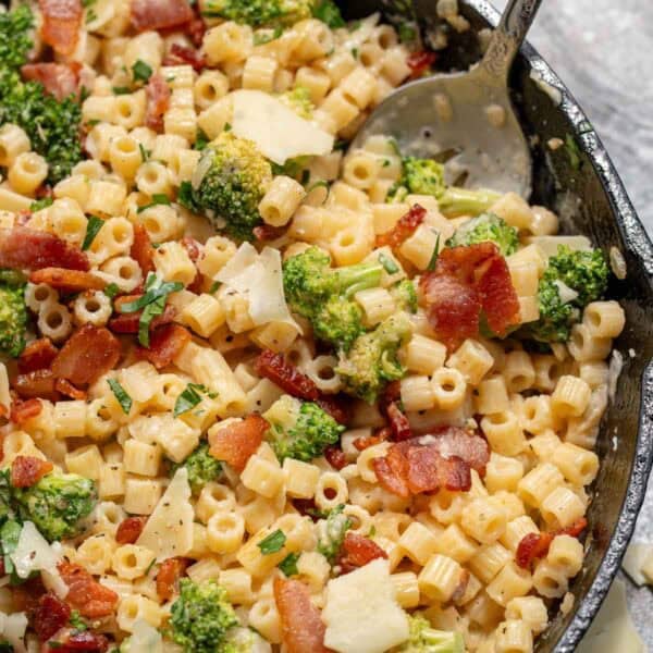 a shot of pasta and broccoli being scooped into a spoon