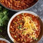an overhead shot of turkey chili in a bowl with cheddar cheese