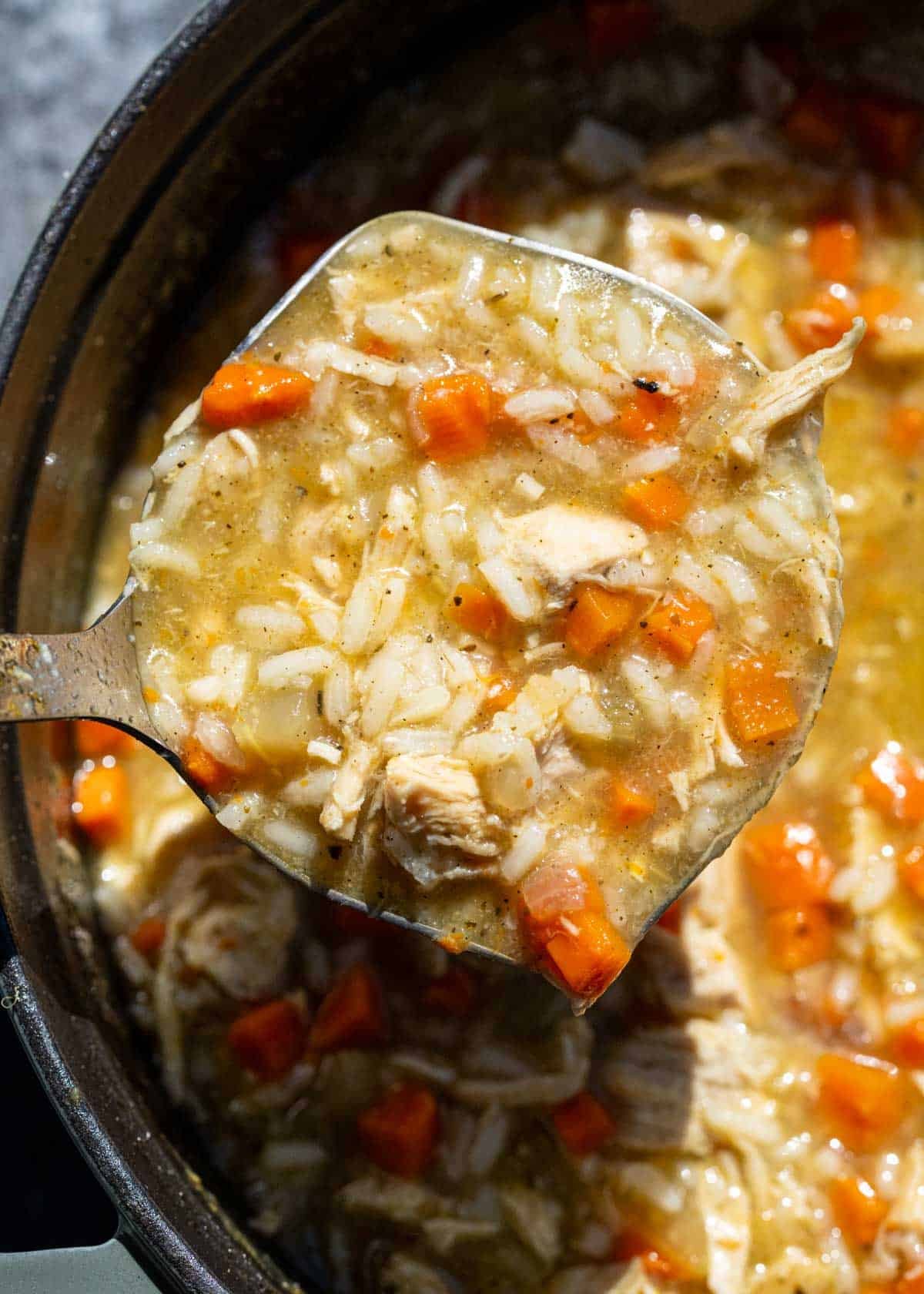 a ladle of chicken and rice soup
