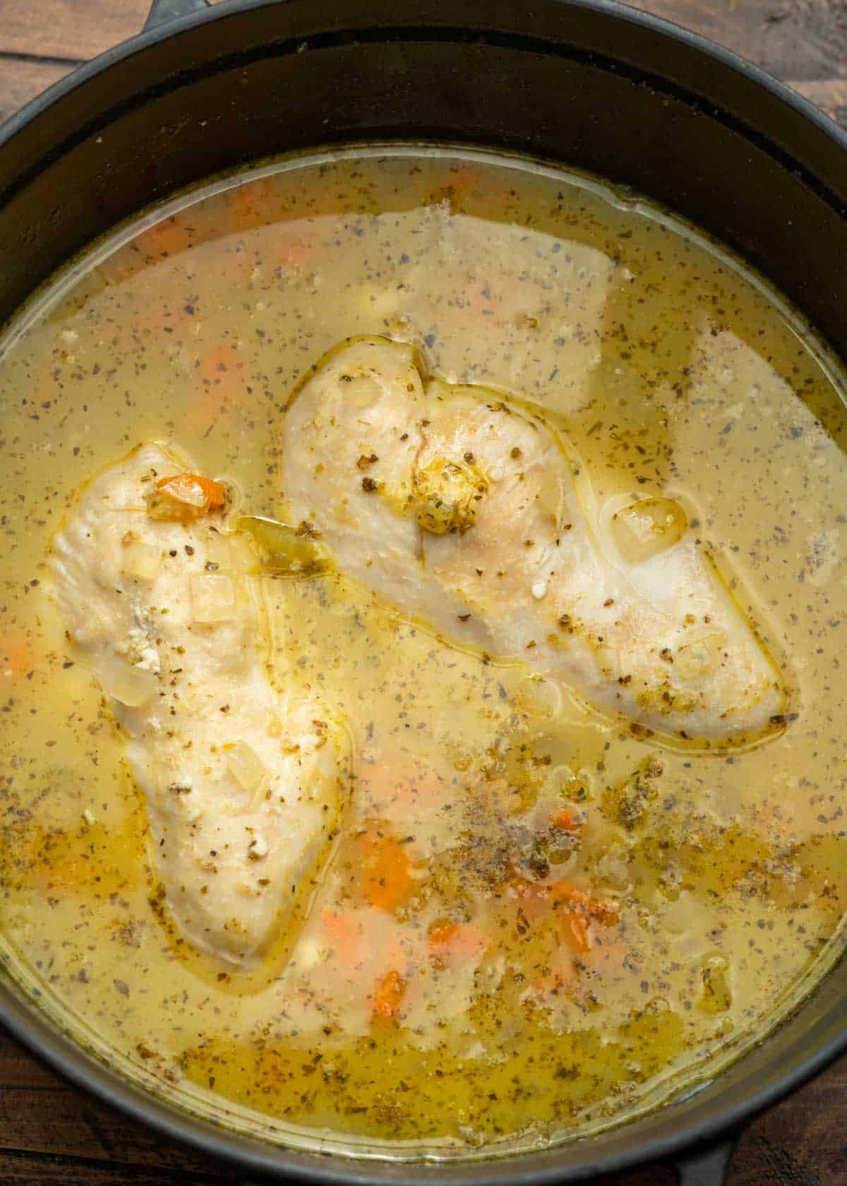 the ingredients for chicken and rice soup in a black pot