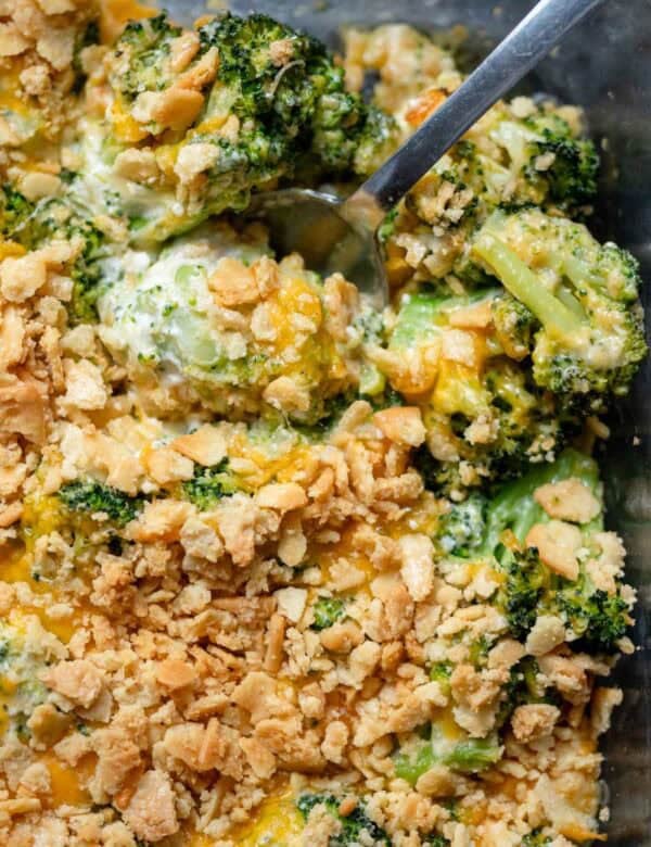 an overhead shot of a cooked broccoli cheese casserole with a spoon in the dish