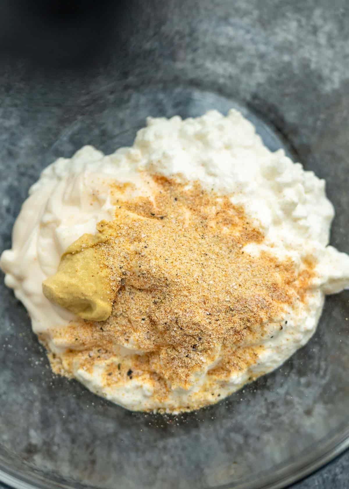 cottage cheese, spices and dijon in a bowl to make broccoli cheese casserole