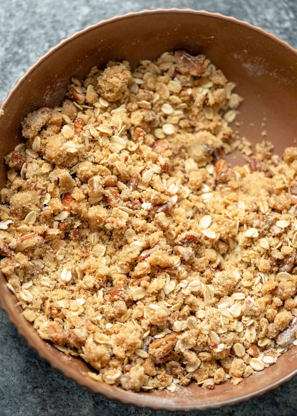 a bowl full of brown sugar pecan topping for sweet potato casserole