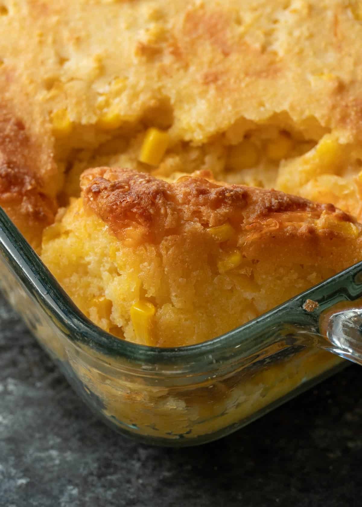 a closeup shot of cornbread casserole in a baking dish