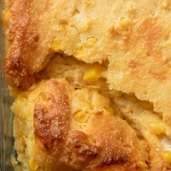 a closeup corn casserole that has been scooped into with a spoon.